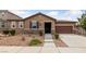 Charming single-story home featuring a stone veneer, desert landscaping, and a two-car garage at 705 Coastal Lagoon St, Henderson, NV 89002