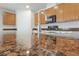Granite countertop with stainless steel sink and faucet in a kitchen with wooden cabinets at 705 Coastal Lagoon St, Henderson, NV 89002