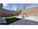 A well-manicured backyard with artificial turf, a built-in grill, and a stone patio, perfect for entertaining at 754 Agate Hills St, Las Vegas, NV 89138