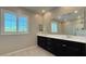 Bathroom featuring double sinks with a black vanity, large mirror, and shuttered windows for natural light at 754 Agate Hills St, Las Vegas, NV 89138