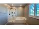 Bright bathroom with a glass-enclosed shower and separate soaking tub next to a shuttered window at 754 Agate Hills St, Las Vegas, NV 89138