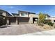 Exterior of a modern home with a brick driveway, three-car garage, and desert landscaping at 754 Agate Hills St, Las Vegas, NV 89138