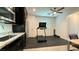 Bright home gym featuring a treadmill, free weights, stainless steel refrigerator, and wet bar at 754 Agate Hills St, Las Vegas, NV 89138