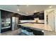 Modern kitchen with stainless steel appliances, dark cabinetry, and granite countertops at 754 Agate Hills St, Las Vegas, NV 89138