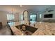 Open-concept kitchen with granite counters, stainless sink, and views of the living room and backyard at 754 Agate Hills St, Las Vegas, NV 89138