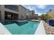 Backyard with a sparkling pool and spa, complemented by stone landscaping and a covered patio at 754 Agate Hills St, Las Vegas, NV 89138