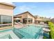 Gorgeous backyard featuring a pool, outdoor seating, kitchen, and lush landscaping at 826 Bolide St, Las Vegas, NV 89138