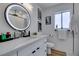 Modern bathroom featuring a sleek vanity, round mirror, and tiled walls, creating a clean and stylish space at 8640 Trafalgar Dr, Las Vegas, NV 89117