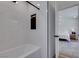 Bathroom featuring tiled walls, a bathtub, and a doorway that leads to a bedroom at 8640 Trafalgar Dr, Las Vegas, NV 89117