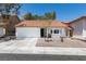 Charming single-story home features a red tile roof, white exterior paint, and a two car garage at 8640 Trafalgar Dr, Las Vegas, NV 89117