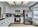 Bright kitchen featuring stainless steel appliances, white cabinets, quartz countertops, and a stainless steel range at 8640 Trafalgar Dr, Las Vegas, NV 89117
