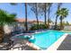 Backyard oasis with a swimming pool, spa, tiled accents, and lush palm trees for ultimate relaxation at 8640 Trafalgar Dr, Las Vegas, NV 89117
