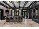 Home bar featuring dark wood cabinets, marble countertop, hanging lights, and a ladder to access wine storage at 9 Clear Crossing Trl, Henderson, NV 89052