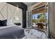 Modern bedroom boasts a luxurious bed with tufted headboard and opens to a patio with outdoor seating at 9 Clear Crossing Trl, Henderson, NV 89052