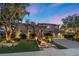 Beautiful two-story home with stone accents, manicured landscaping, and illuminated walkway leading to the front entrance at 9 Clear Crossing Trl, Henderson, NV 89052