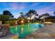 Stunning pool with lush landscaping, water features, and ambient lighting, creating an inviting outdoor retreat at 9 Clear Crossing Trl, Henderson, NV 89052