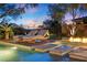 Inviting pool area with lounge chairs, fire pit, and lush landscaping for a serene outdoor experience at 9 Clear Crossing Trl, Henderson, NV 89052