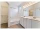 A bathroom with double sinks, tub shower and tile floor at 9303 Gilcrease Ave # 1013, Las Vegas, NV 89149