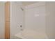 Bright bathroom shower-tub combination with white tiles and a wood-tone storage cabinet at 950 Seven Hills Dr # 1921, Henderson, NV 89052
