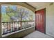 Outdoor patio with black railing, brown door and a view of mature trees at 950 Seven Hills Dr # 1921, Henderson, NV 89052
