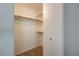 Bright walk-in closet features wood rods, white shelving and brackets, and neutral carpet at 950 Seven Hills Dr # 1921, Henderson, NV 89052