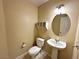 Cozy powder room featuring a pedestal sink, wall mounted shelves, and a modern light fixture at 1006 Winding Hill St, Henderson, NV 89002