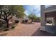 A private backyard with desert landscaping, mature trees, and a covered patio at 10066 Golden Bluff Ave, Las Vegas, NV 89148