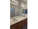 A spacious bathroom with double sinks, a large mirror, and warm wood cabinetry at 10066 Golden Bluff Ave, Las Vegas, NV 89148
