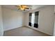 This bedroom has carpet flooring, a ceiling fan, and a window with striped curtains at 10066 Golden Bluff Ave, Las Vegas, NV 89148