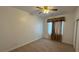 This bedroom has carpet flooring, a ceiling fan, and a window with brown curtains at 10066 Golden Bluff Ave, Las Vegas, NV 89148