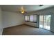 Large bedroom with carpeting, two windows, and a sliding glass door at 10066 Golden Bluff Ave, Las Vegas, NV 89148