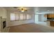 Spacious living room featuring a fireplace, neutral carpet, and access to the kitchen at 10066 Golden Bluff Ave, Las Vegas, NV 89148