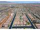 Wide aerial shot of a vibrant neighborhood with homes, green spaces, and community pools under a vast sky at 10416 Skye Arroyo Ave, Las Vegas, NV 89166