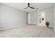 Large bedroom featuring neutral carpet, ceiling fan and a doorway to the bathroom at 10416 Skye Arroyo Ave, Las Vegas, NV 89166
