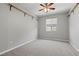Neutral bedroom with carpeted floor, a window for natural light, ceiling fan and wall shelving at 10416 Skye Arroyo Ave, Las Vegas, NV 89166