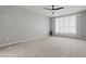 Spacious bedroom with neutral carpet, ceiling fan, and bright natural light from the window at 10416 Skye Arroyo Ave, Las Vegas, NV 89166