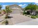 Charming single-story home featuring a brick driveway, desert landscaping, and two-car garage at 10416 Skye Arroyo Ave, Las Vegas, NV 89166