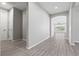 Bright hallway features wood-look tile flooring leading to living area, plus white doors and gray walls at 10416 Skye Arroyo Ave, Las Vegas, NV 89166