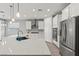 Close-up of the kitchen with white cabinets, stainless steel appliances, quartz countertops and pendant lights at 10416 Skye Arroyo Ave, Las Vegas, NV 89166