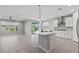 Bright, open kitchen features a center island, white cabinets, stainless steel appliances, and tile floors at 10416 Skye Arroyo Ave, Las Vegas, NV 89166