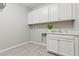Laundry room features white cabinets, sink, and tile flooring at 10416 Skye Arroyo Ave, Las Vegas, NV 89166