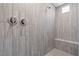 Close-up of walk-in shower with modern chrome fixtures and stone tile detail at 10416 Skye Arroyo Ave, Las Vegas, NV 89166