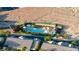 Community pool with cabanas surrounded by desert landscaping and a green fence at 11082 Sospel Pl, Las Vegas, NV 89141