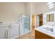 Bathroom featuring a walk-in bathtub, glass-enclosed shower, and double sinks at 11082 Sospel Pl, Las Vegas, NV 89141