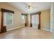 Bright bedroom featuring tile floors, tan walls, a ceiling fan, and three windows with decorative curtains at 11082 Sospel Pl, Las Vegas, NV 89141
