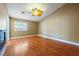 Bedroom featuring wood floors, tan walls, white trim, a ceiling fan, and a fireplace at 11082 Sospel Pl, Las Vegas, NV 89141