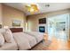 Serene primary bedroom featuring a fireplace, ceiling fan, wood floors, and adjacent bonus room at 11082 Sospel Pl, Las Vegas, NV 89141