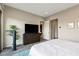 Bright bedroom showcasing a TV atop a dresser, neutral walls, and a plant at 11672 Barga Ct, Las Vegas, NV 89138