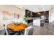 A stylish dining area featuring a wooden table, gray chairs, and an open view into the modern kitchen at 11672 Barga Ct, Las Vegas, NV 89138