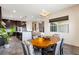 A modern dining area showcasing a wooden table, stylish gray chairs, with a view into the gourmet kitchen at 11672 Barga Ct, Las Vegas, NV 89138